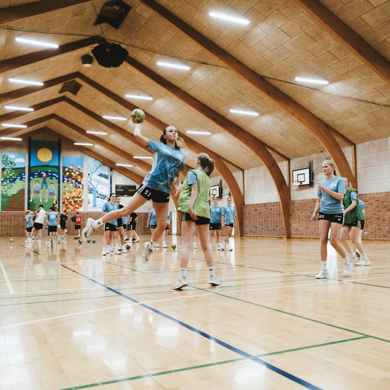 Efterskoleelever spiller håndbold i hal på Gudenaadalens efterskole. 