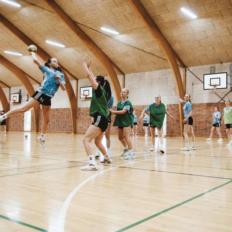 Efterskoleelever spiller håndbold i hal på Gudenaadalens efterskole. 