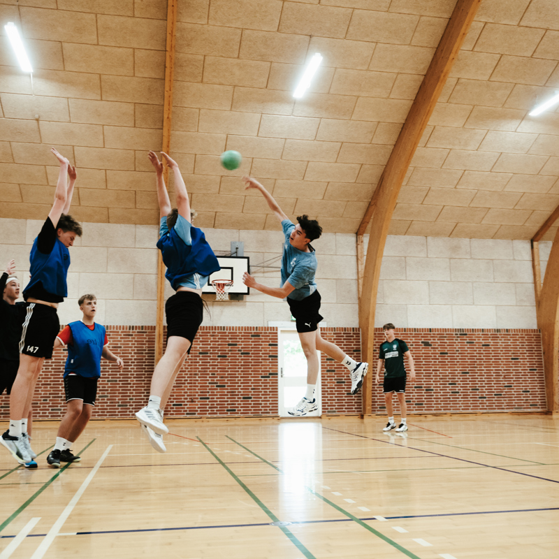 Efterskoleelever spiller håndbold i hal på Gudenaadalens efterskole. 