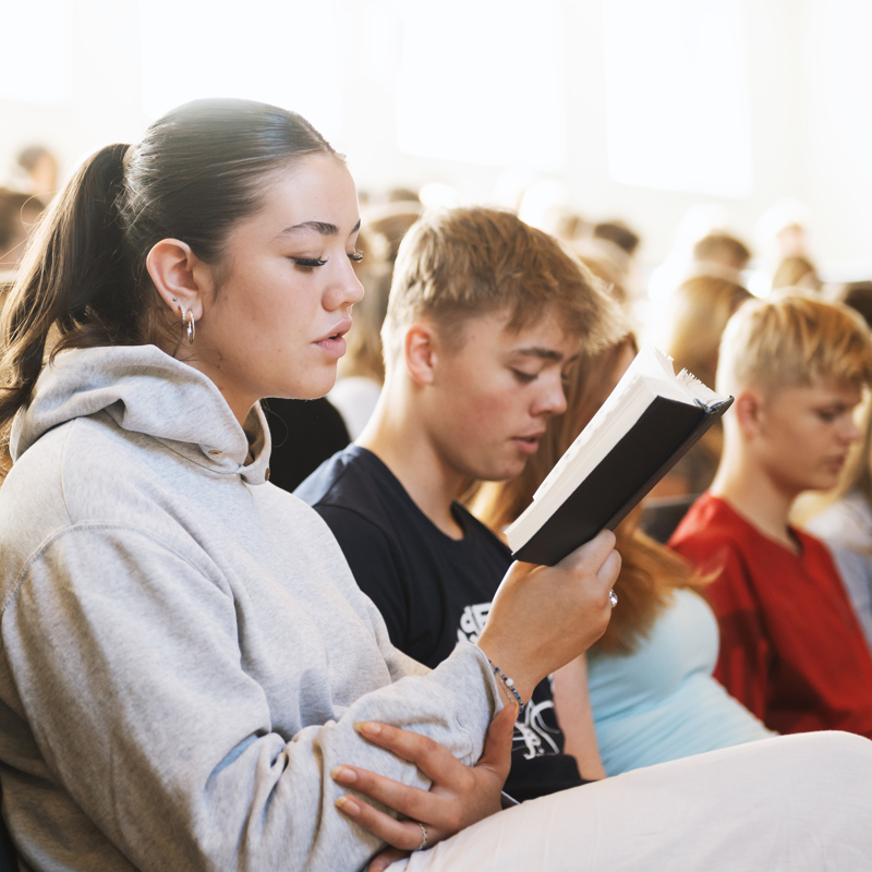 Efterskoleelever synger til fællessamling på Gudenådalens efterskole. 