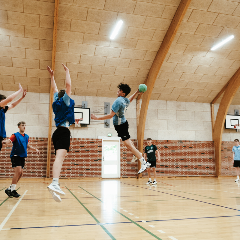 Efterskoleelever spiller håndbold i hal på Gudenaadalens efterskole. 